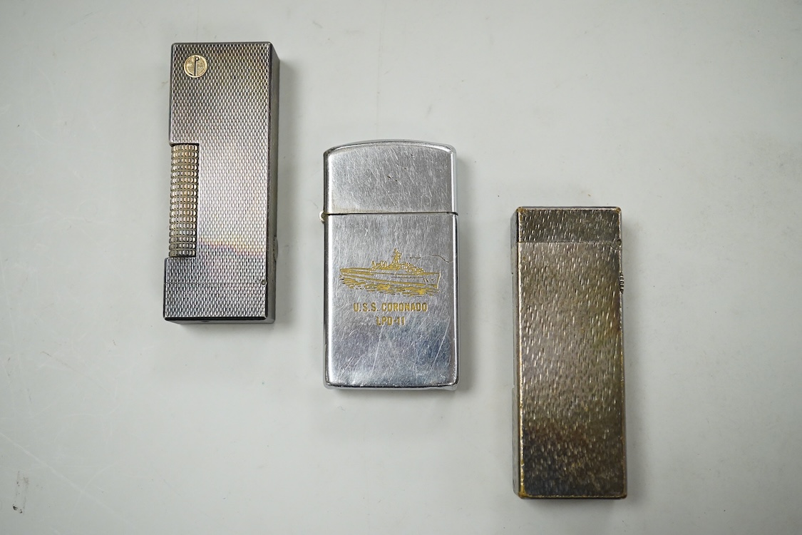 Two Dunhill rollagas silver plated lighters, barley pattern and rusticated 6.5cm long and a U.S.S. Coronado LPD-11, zippo lighter (3)